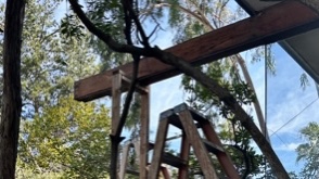 A ladder under a wood beam